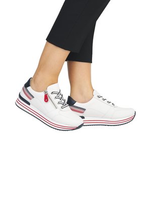 Weißes Sportbekleidung mit schwarzen Akzenten und roten Streifen. Merkmale sind eine Schnürung vorne, ein Reißverschlussdetail und eine strukturierte Sohle.