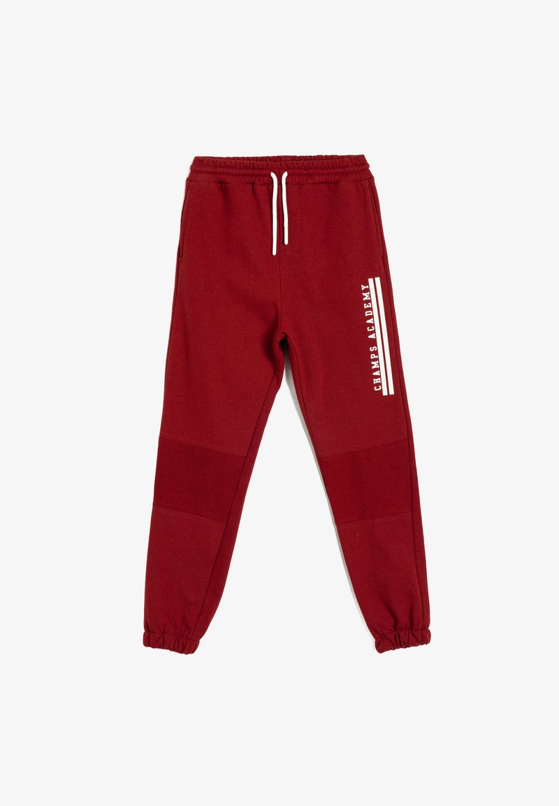 Røde sweatpants lavet af blødt stof, med en elastisk talje med snor, elastiske manchetter og et hvidt logo på siden.