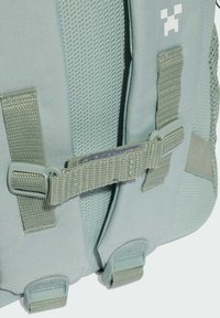 Svijetloplavi ruksak s detaljima od mrežice, najlonskim remenima i kopčama. Uključuje teksturirane naglaske i mali logo u gornjem kutu.