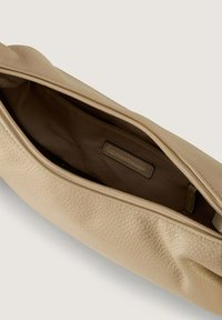 Borsa in pelle beige con superficie testurizzata, dotata di chiusura a zip e foderata internamente in tessuto marrone. Un'etichetta è visibile all'interno della tasca.