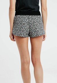 Svarta blommiga shorts med vita och rosa mönster, med en texturerad svart midjeband och en avslappnad passform som slutar vid mitten av låret.