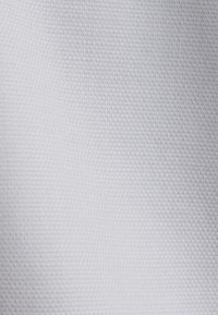 Tissu blanc avec une texture fine tissée présentant un motif subtil en quadrillage de petits carrés en relief.