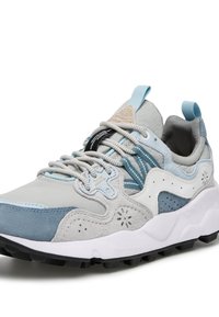 Zapatillas de deporte en gris claro y azul que combinan materiales de ante y malla, con acentos texturizados y una suela intermedia blanca prominente y suela exterior negra.