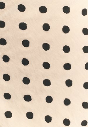 Bomuldsstof med beige baggrund og et mønster af jævnt fordelt, strukturerede sorte prikker. Prikkerne varierer en smule i størrelse og form.