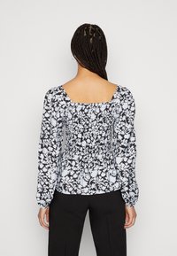 Blusa com padrão floral, apresentando mangas longas e volumosas, decote quadrado e cintura franzida. As cores incluem preto, branco e azul claro.