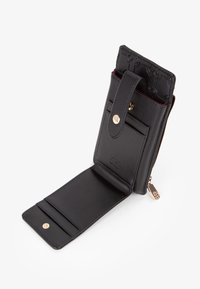 Portafoglio in pelle nera con una finitura texturizzata, dotato di chiusura a scatto, scomparti interni per carte e dettaglio con zip dorata.