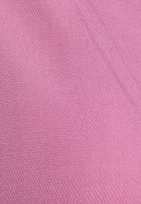 Tessuto rosa testurizzato con un sottile motivo diagonale, caratterizzato da una superficie liscia e una finitura morbida. Ideale per applicazioni di tappezzeria o abbigliamento.