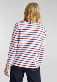 Camicia a maniche lunghe a righe bianche, con righe orizzontali rosse e blu. Tessuto morbido con una vestibilità comoda e dettaglio con bottoni ai polsini.