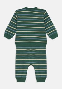 Green, blue, and beige striped long-sleeve top and matching pants set with ribbed cuffs and waistband laid flat on white background.