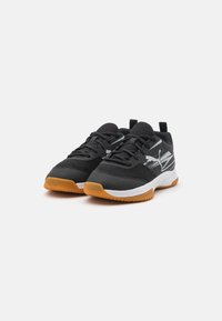Chaussures de sport noires avec une tige en maille texturée, arborant un logo blanc et gris et une semelle en caoutchouc couleur gomme. Lacets et design de col rembourré.