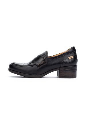 Mocassins en cuir noir avec un petit talon empilé, présentant un panneau avant texturé et des coutures décoratives. Détail de marque sur le talon.