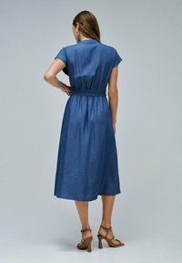 Vestido midi de denim con mangas cortas, cinturón ajustable a la cintura y silueta recta. Color: azul oscuro. Textura: tejido suave y ligero.