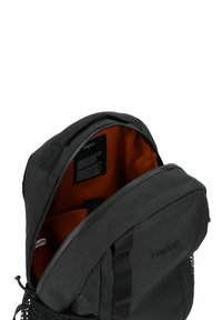 Zaino nero con un motivo geometrico, interno arancione, scomparto principale con zip e tasca laterale in rete. Etichetta del marchio visibile all'interno.