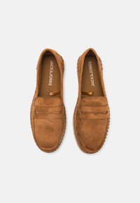 Brown suede slip-on shoes with a rounded toe, decorative stitching, and a textured sole. Brand name "JACK & JONES" visible on the insoles.