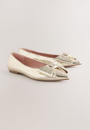Gouden, gestructureerde balletschoenen met spitse neuzen, strikaccent aan de voorkant en een vlakke zool. Gladde, glanzende afwerking met metallic glans.