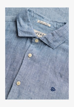 Lyseblå, stribet skjorte med knapper, hvide knapper, krave med foldede kanter og broderet lille blåt fiskelogo på brystet.