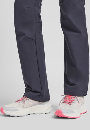 Chaussures de sport légères en blanc avec des accents roses, dessus en maille texturée, bout renforcé, semelle rembourrée et profil profond pour une meilleure adhérence.