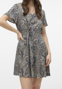 Hame pitkähihaisella hihalla harmaana paisley-kuvioisena, jossa on V-pääntie ja joustava vyötärö, valmistettu kevyestä kankaasta.