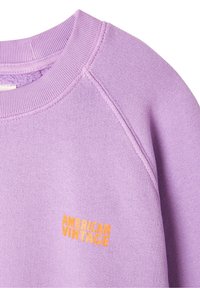 Fioletowa bluza z okrągłym dekoltem, prążkowaną strukturą i pomarańczowym haftem "AMERICAN VINTAGE" z przodu.