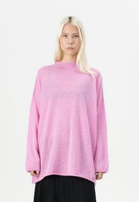 Roza prevelika pulover iz mehkega materiala, z visokim ovratnikom, dolgimi rokavi in ohlapnim krojem. Gladka tekstura z rahel sijaj.