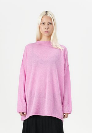 Rosa oversized genser laget av mykt materiale, med høy krage, lange ermer og en løs passform. Glatt tekstur med en subtil glans.