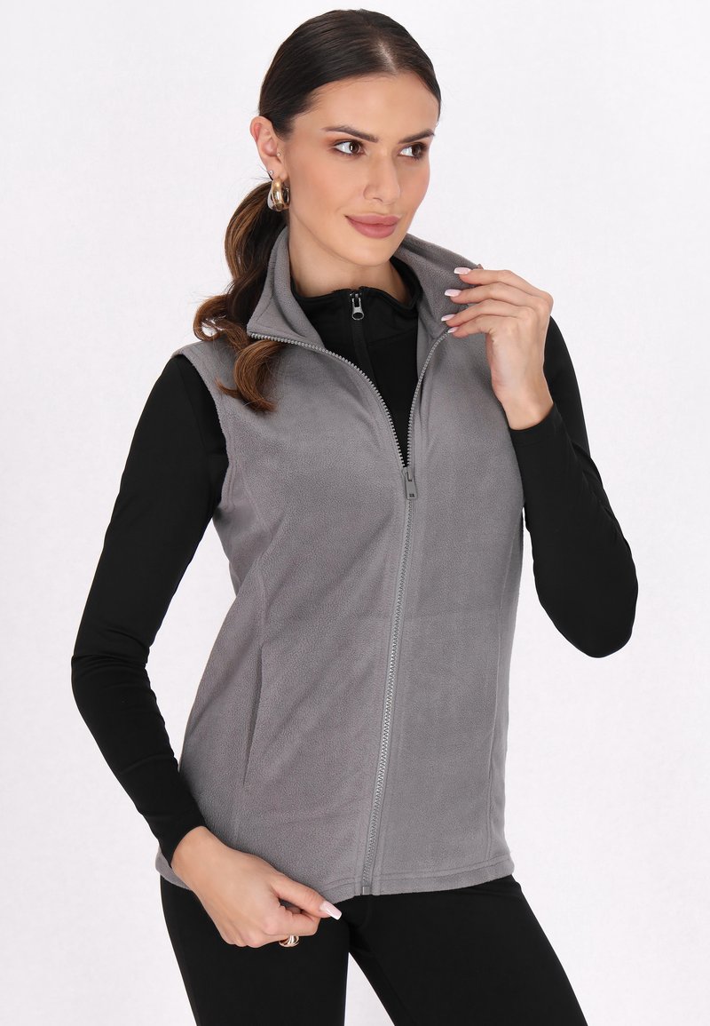 Gilet in pile grigio con colletto alto, zip frontale e tasche laterali. Tessuto morbido, design leggero, adatto per essere indossato sopra altri capi.