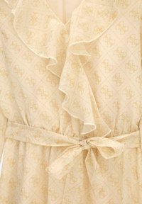 Robe beige clair avec un col à volants, présentant un motif monogramme subtil et une ceinture nouée à la taille pour un ajustement personnalisé. Tissu doux et léger.