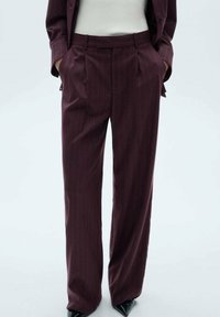 Burgundske krojene hlače imaju uzorak s pinstripes, nabran prednji dio i opušteni kroj. Izrađene su od glatkog materijala s fino teksturom.