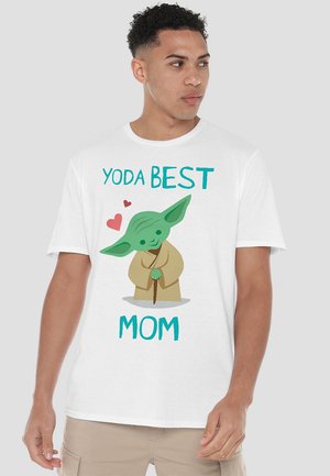 White short-sleeve T-shirt featuring a cartoon character resembling a green alien with oversized ears, text reading "YODA BEST MOM," and hearts.