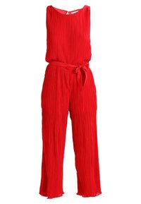 Combinaison sans manches plissée rouge avec col rond, taille ceinturée et jambes évasées.
