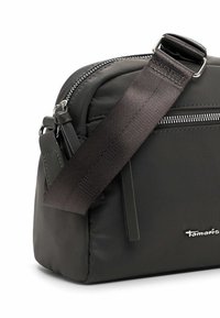 Black nylon crossbody bag with a textured strap, zip closure, and branded detail. Compact, rectangular design with smooth finish.