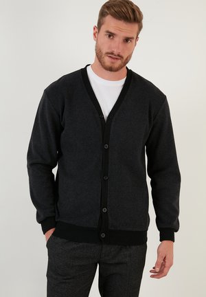 Dunkelgrauer Cardigan aus weichem Stoff, mit V-Ausschnitt, schwarzen Knöpfen und gerippten Bündchen und Saum. Glatte Textur mit einfachem Design.