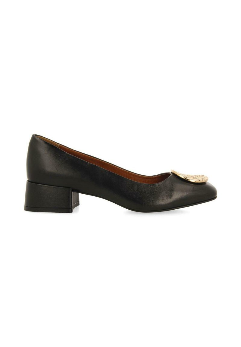 Zwarte leren pump met een ronde neus, lage blokhak en decoratieve metalen accent aan de voorkant. Glad textuur en subtiel ontwerp.