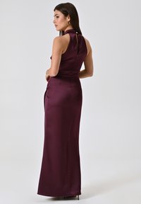 Langes burgunderrotes Satin-Kleid mit hohem Kragen, Knopfverschluss auf der Rückseite und figurbetonter Silhouette, das an der Seite einen Schlitz für zusätzlichen Detailreichtum aufweist.