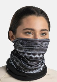 Cuello tubular de patrón en negro y gris hecho de tela elástica con un logo; textura suave, forma cilíndrica, adecuado para clima frío.