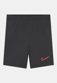Svarta träningsshorts med elastisk midja och röd Nike-swoosh-logotyp på nedre vänstra benet, uppvisade platt på en vit bakgrund.
