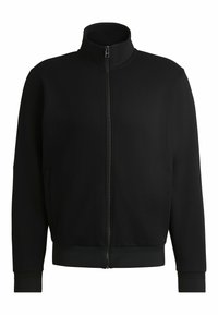 Zwarte zip-up jack met hoge kraag, gemaakt van gladde stof. Heeft ribgebreide manchetten en onderzoom, met zijzakken en minimale details.