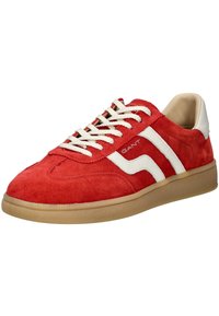 Baskets en daim rouge avec des accents en cuir blanc, présentant un design classique, des lacets plats et une semelle en caoutchouc texturé couleur gomme.