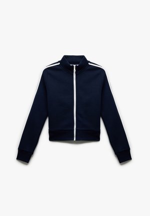 Marineblauwe zip-up sportjack met witte zijkanten. Voorzien van een hoge kraag en geribbelde manchetten. Gemaakt van een soepele, rekbare stof.