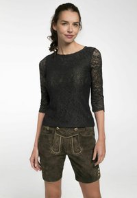 Schwarzes Spitzenoberteil mit Drei-Viertel-Ärmeln, kombiniert mit olivgrünen Wildleder-Shorts, die mit dekorativen Nähten und goldfarbener Hardware versehen sind.