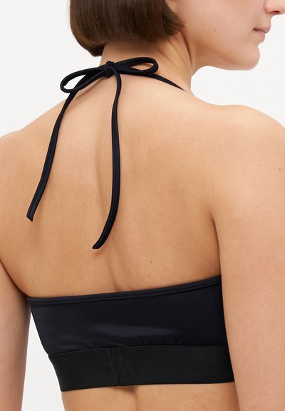 Black halter neck bralette with a smooth fabric, wide elastic band at the base, and adjustable tie at the back.