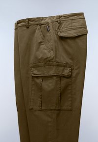 Olive green cargo pants showing a front pocket with flap, a side cargo pocket with flap, belt loops, and visible stitching details.