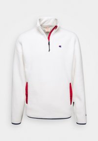 Weißer Fleece-Pullover mit roten seitlichen Akzenten, Reißverschlusskragen und gesticktem Logo auf der linken Brust. Hat marinefarbene Abschlüsse an den Ärmelbündchen.