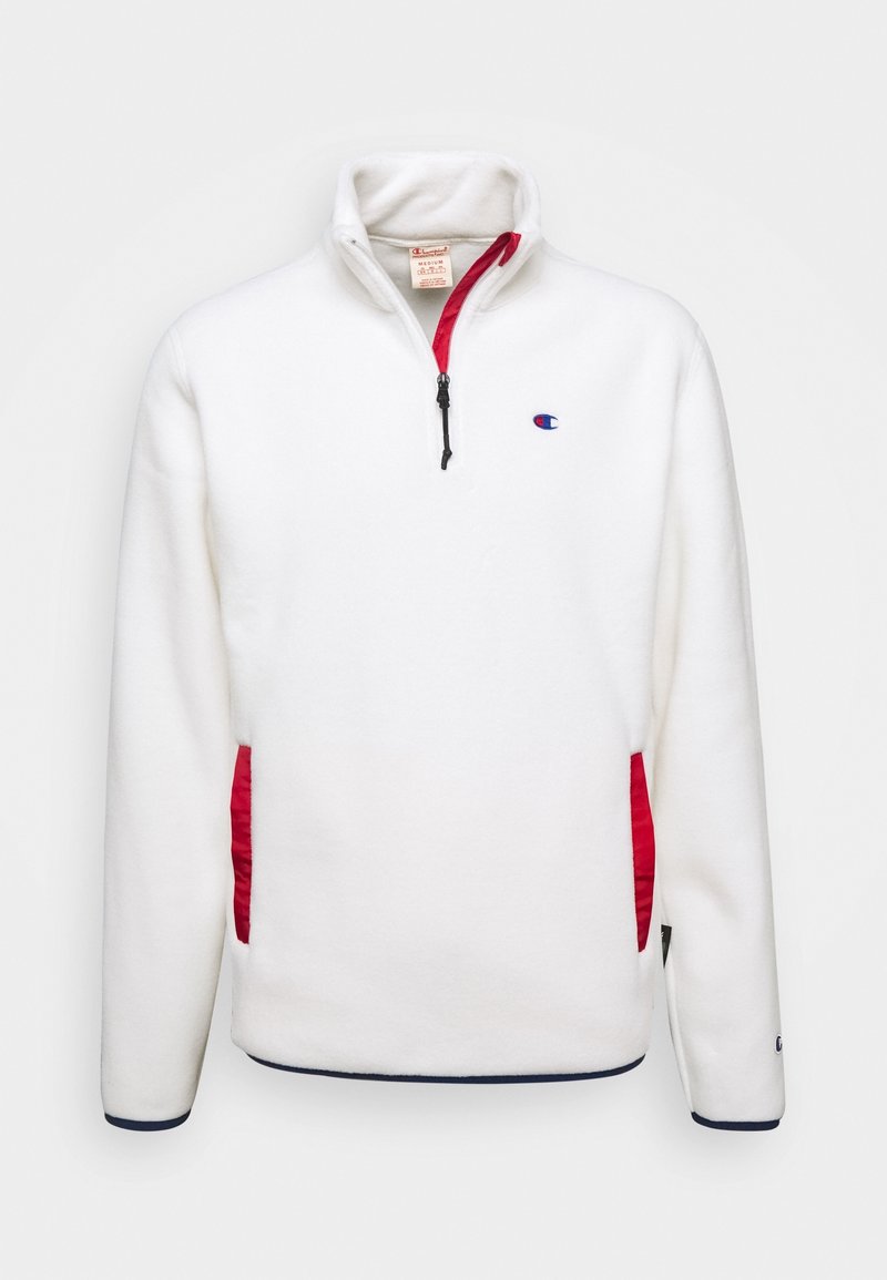 Weißer Fleece-Pullover mit roten seitlichen Akzenten, Reißverschlusskragen und gesticktem Logo auf der linken Brust. Hat marinefarbene Abschlüsse an den Ärmelbündchen.