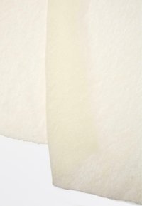 Hvidt stof med en blød tekstur, der har to sektioner: en lidt mørkere beige og en lysere creme, med en glat overflade.