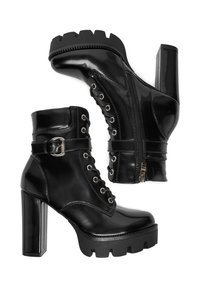 Černé lakované kozačky ke kotníkům s robustními vysokými podpatky, předními šněrováním, bočními zipy a dekorativním páskem se sponou na bílém pozadí.