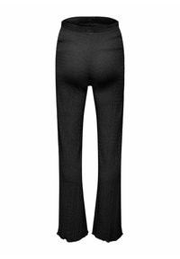 Pantalon noir texturé à jambes droites avec un ourlet légèrement évasé et une ceinture élastique, présenté de dos sur un fond blanc.