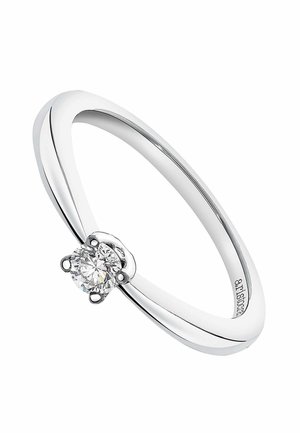Anillo de plata pulida y delgada con un solo diamante cortado en forma redonda, sostenido por cuatro garras, sobre un fondo blanco.