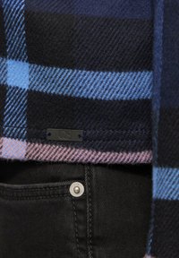 Wollen plaid sjaal in marineblauw, lichtblauw en roze met zwarte accenten; beschikt over een QS-label en een zwarte denim zak met zilveren knoopdetails.