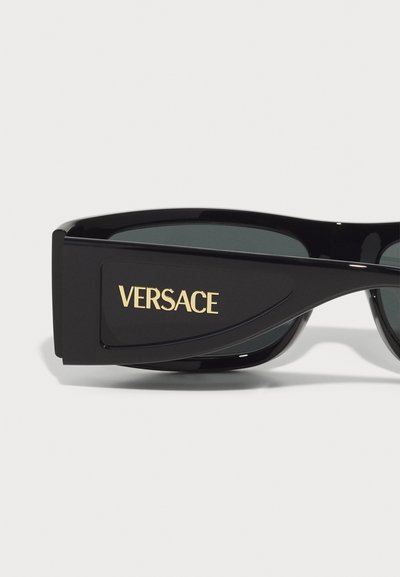Juodos saulės akinius su žaliais lęšiais; stačiakampio formos rėmas su išryškintu auksiniu "VERSACE" logotipu šone; blizgus paviršius.